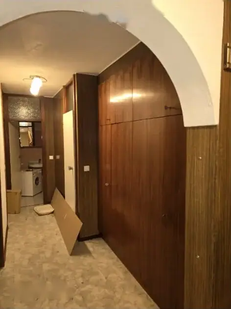Vorzimmer mit dunkler Holzvertäfelung und Einbauschrank vor der Räumung
