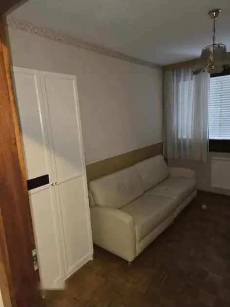 Zimmer mit Schlafsofa und weißem Einbauschrank